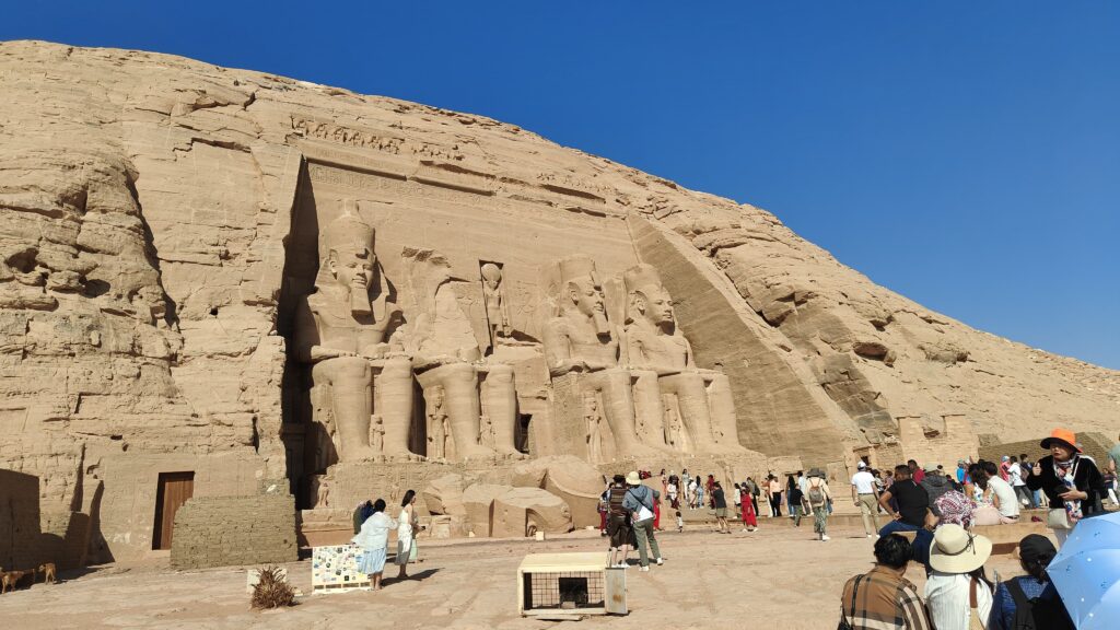 Tourists exploring the colossal statues of Pharaoh Ramses II at Abu Simbel Temple in Egypt
