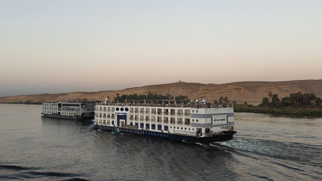 Luxury Nile cruise ship sailing on the Nile River at sunset with desert hills in the background, Egypt