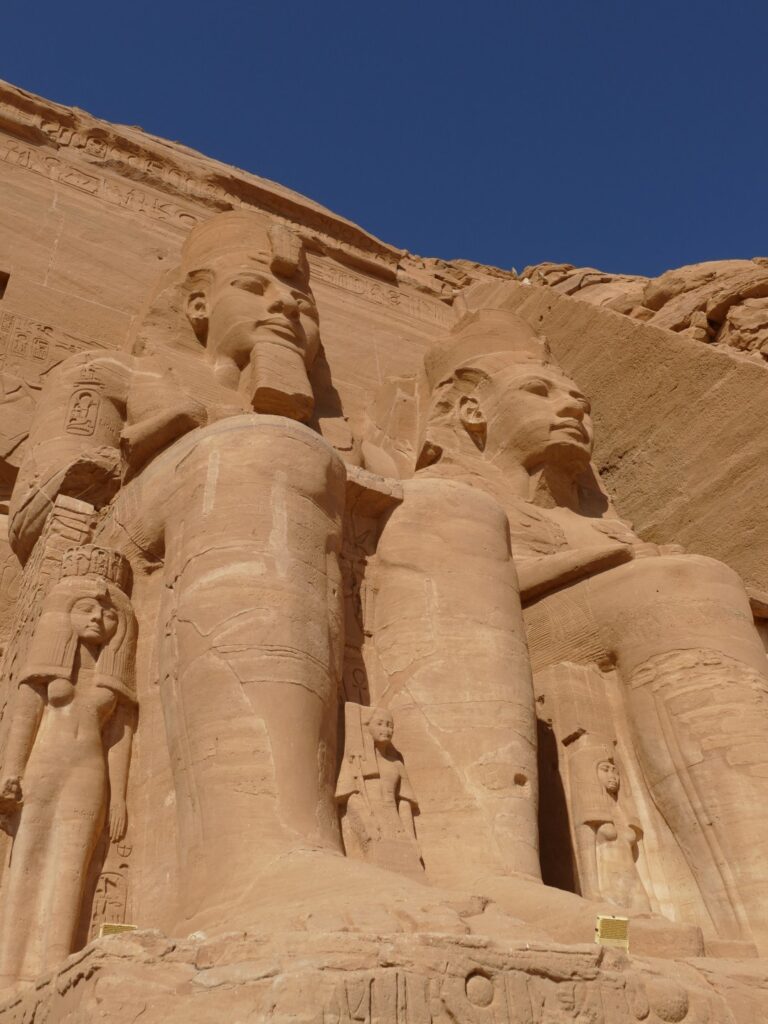 Giant statues of Pharaoh Ramses II at Abu Simbel Temple in southern Egypt under clear blue sky