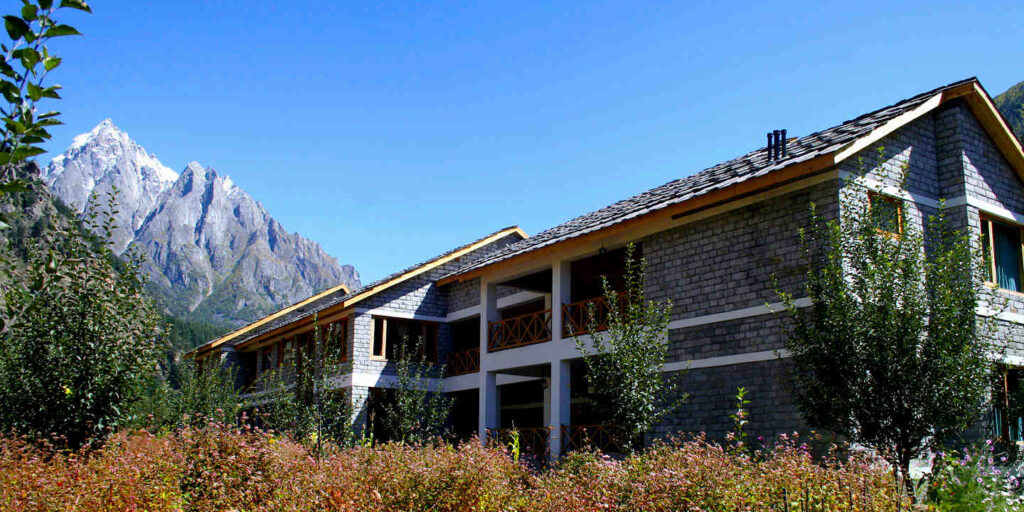 The stay at Sangla has the backdrop of snow-clad peaks and is next to Baspa River.