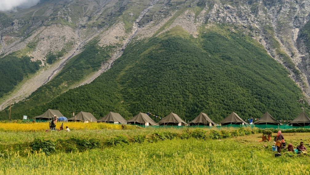 Swiss tents in green fields at Sural Bhatori village in Pangi Valley surrounded by steep Himalayan mountains (Himalayan Overland Safari)