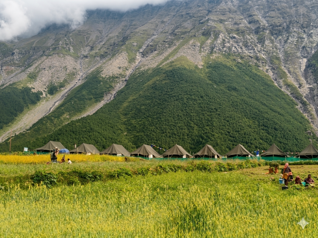 Swiss tents in green fields at Sural Bhatori village in Pangi Valley surrounded by steep Himalayan mountains