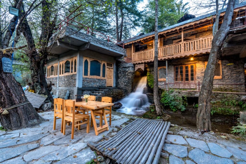 Riverside stay in Chamba Himachal Pradesh with traditional wooden architecture and flowing stream
