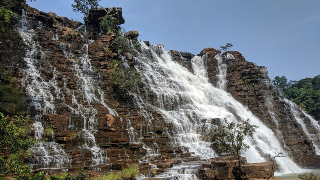 a massive, cascading tiered waterfall surrounded by rocky cliffs.