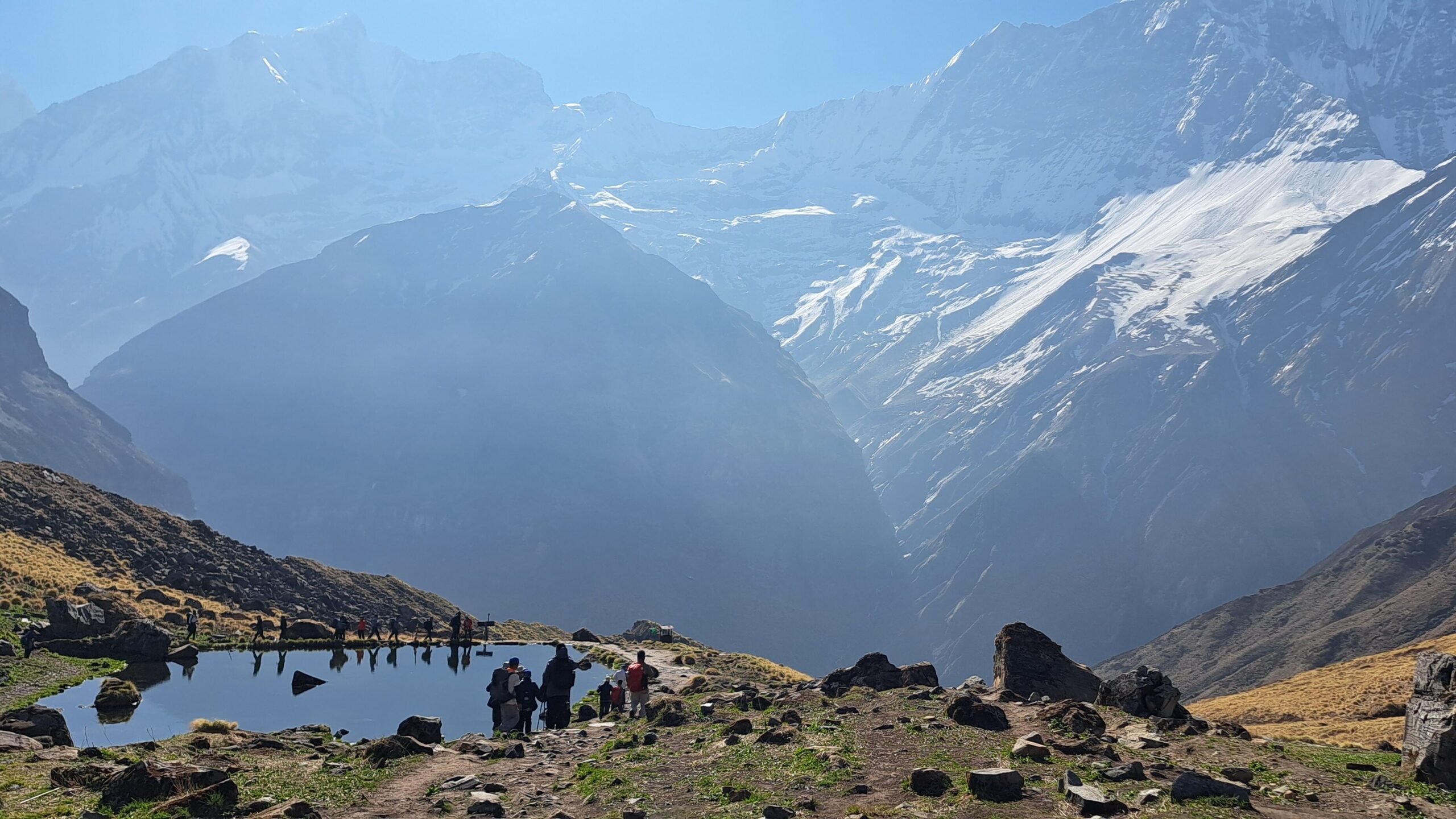 Mountain pond at Deurali with snow-covered Himalayan peaks and glaciers on the Annapurna Base Camp Trek in Nepal.