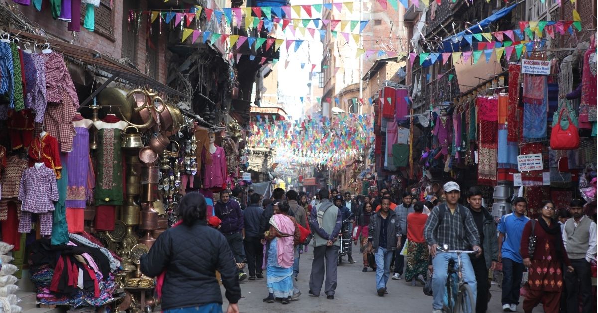 Busy street in Thamel, Kathmandu, with shops on both sides, trekkers, cafés, and local markets before the Annapurna Base Camp Trek.